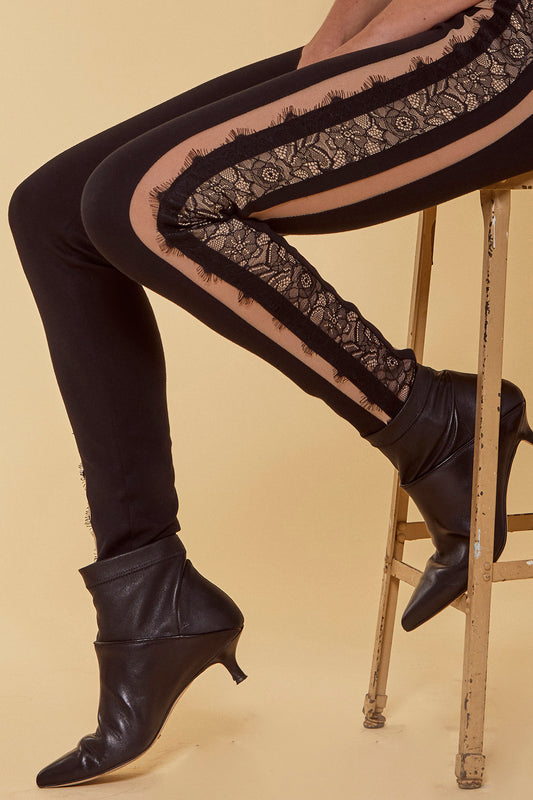 A ponte legging style pant with a fitted mid-rise, lace edge trim, power mesh panels and hidden back zipper in black.